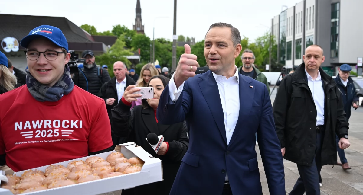 Karol Nawrocki, kandydat na prezydenta RP popierany przez PiS podczas częstowania drożdżówkami przed dworcem stacji kolejowej Gdańsk Wrzeszcz (fot. PAP)