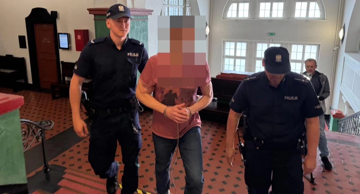 Adam U. w eskorcie policji przed pierwszą rozprawą (fot. archiwum DE)